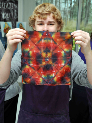 Student holding tie dye scarf